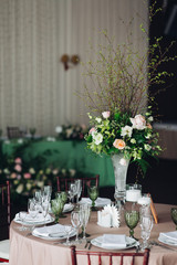 Beautiful composition with flowers on the tables and candles for guests at a wedding or a birthday party