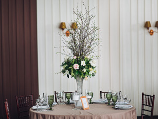 Beautiful composition with flowers on the tables and candles for guests at a wedding or a birthday party
