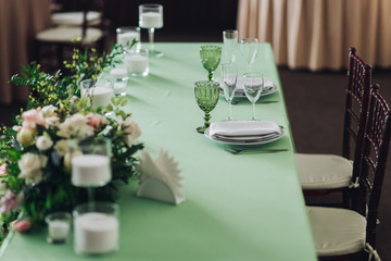Beautiful composition with flowers on the tables and candles for guests at a wedding or a birthday party
