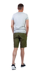 Back view of going handsome man in shorts.