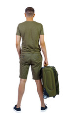 Back view of man in shorts with suitcase.
