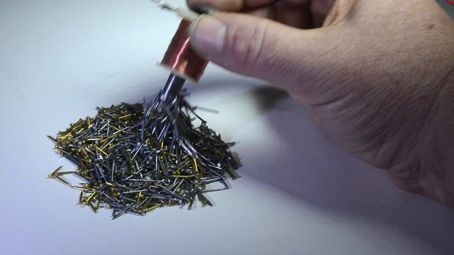 A mix of brass nails and iron nails are easily sorted with an electromagnet.