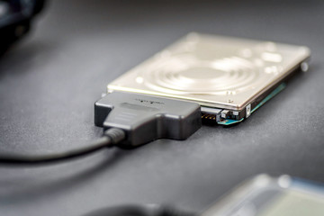 hdd 2.5 hard drive disk connected to smartphone via sata usb cable closeup view