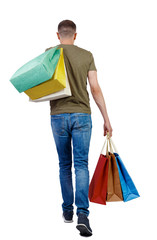Back view of going man with shopping bags