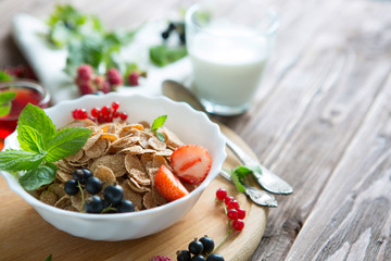 Breakfast Cereal, Table setting. Healthy tasty breakfast multigrain wholewheat healthy cereals with strawberries, raspberries, black currants and red currants.
