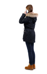 back view of woman in winter jacket talking on mobile phone
