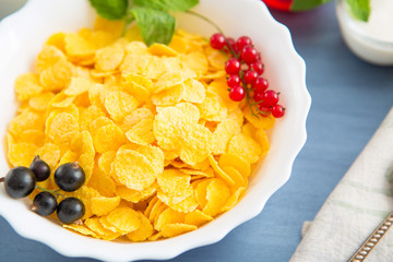 oatmeal with nuts and dried fruits on old white painted wooden table. Perfect breakfast Healthy tasty breakfast cornflakes with strawberries, raspberries, black currants and red currants.