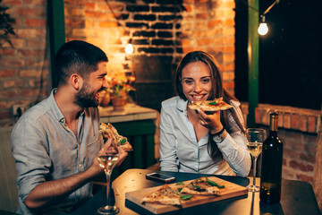 romantic couple having pizza dinner at home in backyard, at evening