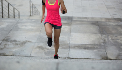 Young fitness sports woman running upstairs on stone stairs