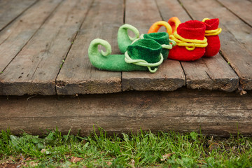 Two pairs of magic boots with curved noses stand on the wooden threshold of the house.