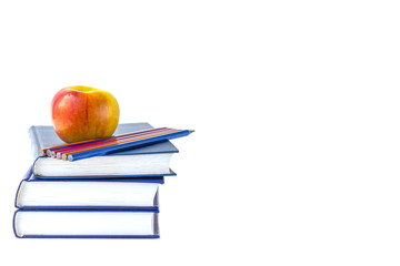 Education or back to school concept. An apple and multi-colored pencils on a stack of book