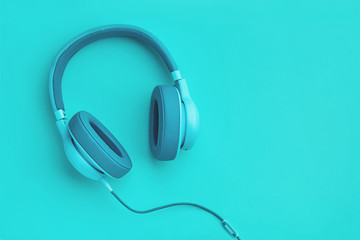 Turquoise headphones a colored background. Music concept with copyspace. Blue headphones isolated