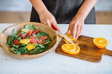 Crop hand passing green salad in white bowl while friends eating together