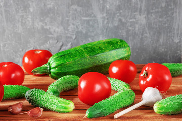 Background from fresh whole vegetables. Raw tomatoes, cucumbers, garlic and zucchini. Copy space.