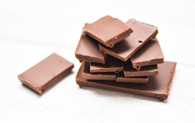 chocolate bar stacked on the white wood background / close up Chocolate pieces candy sweet dessert and snack