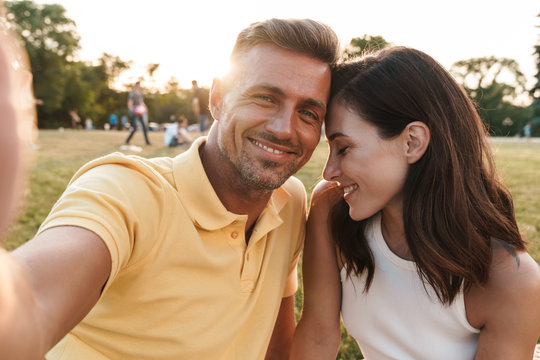 Portrait gorgeous middle-aged couple man and woman taking selfie photo and smiling in summer park