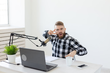 Radio host, streamer and blogger concept - Handsome man working as radio host at radio station...