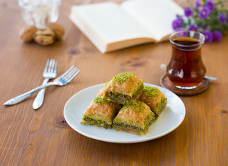 Traditional baklava with Turkish tea on wooden table