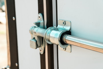 Photograph of a metal lock on a white door