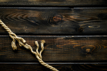 Tearing the rope under stress on wooden background top view copyspace