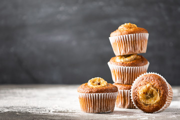 Homemade banana muffins in a stack on a gray background. Healthy vegan dessert. Close-up selective focus. Copy space