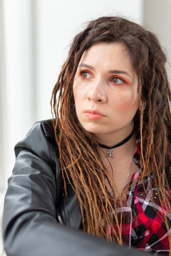 Fashion and beauty concept - young stylish woman in dreadlocks and colourful makeup
