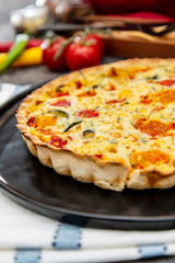 vegetable pie with cherry tomatoes, grilled peppers and courgettes with fresh eggs and fresh cream