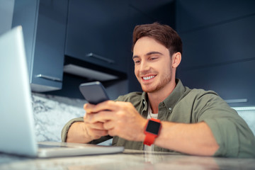 Man smiling while reading message from girlfriend