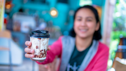 Blured of Asia women giving coffee cup
