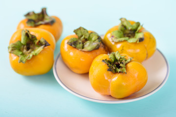 Fresh persimmon fruit on pastel background