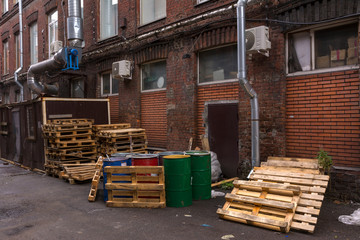 Barrels and pallets are in the yard of the warehouse