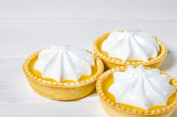 White aircake with lemon filling and lemon on a wooden table