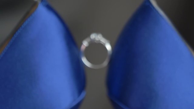 Macro engagement ring in between to blue heels move in