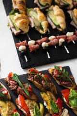 tasty and delicious catering stands on stone trays and on white wooden tables