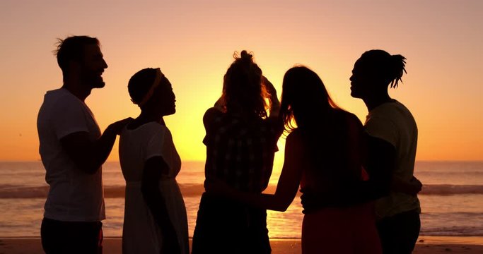 Young adult friends taking selfies on the beach at sunset 4k