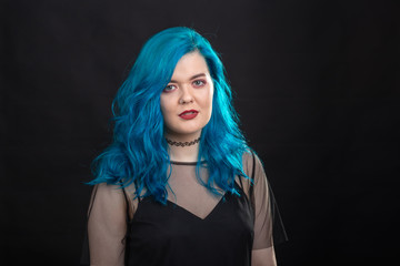 Sryle and fashion concept - Close up portrait of woman with blue long hair over black background