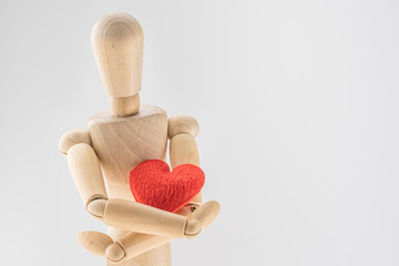Concept of love valentine day, Wooden human toy  holding a red hearts
