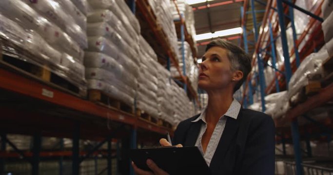 Female manager checks stock in a warehouse 4k