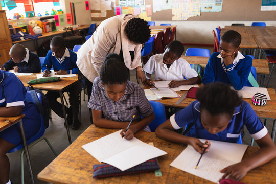 Teacher helping schoolchildren in a lesson at a township school