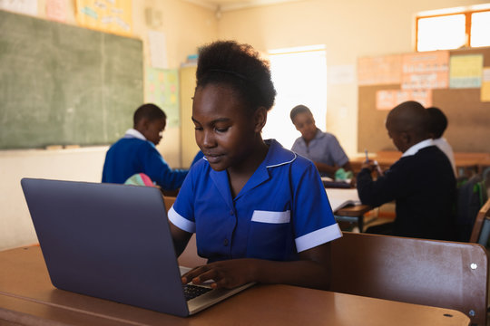 Schoolgirl using laptop in a lesson at a township school