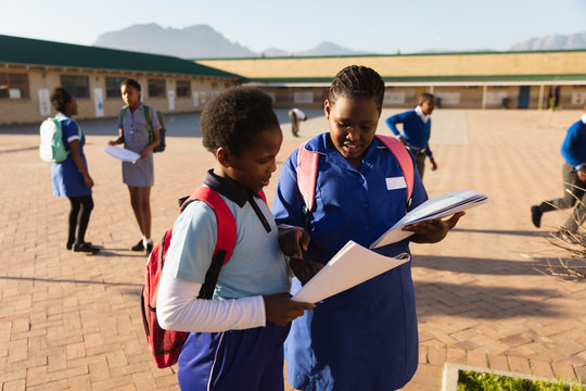 Schoolgirls in the playground with books