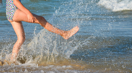 Fototapeta premium Running young girl legs on the beach and copy space