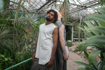 Models enjoying fresh air while posing in greenhouse with palms