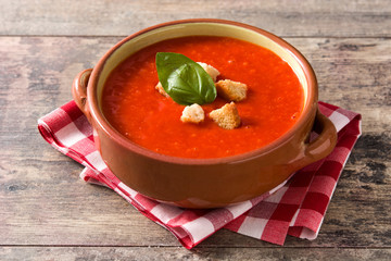 Tomato soup in brown bowl on wooden table