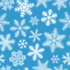 Fototapeta na wymiar Christmas seamless pattern of white defocused snowflakes on light blue background