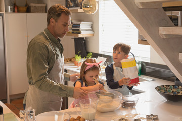 Father with his children preparing food in kitchen