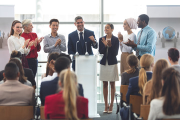 Businessman standing at podium with colleagues and speaks in a business seminar