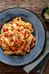 Pasta bolognese. Traditional italian dish of pasta with tomato and meat mince sauce served in a plate with parmesan cheese and thyme, top view