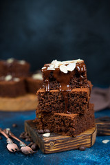 Traditional Belgian chocolate brownies decorated with warm chocolate lie on a wooden Board....