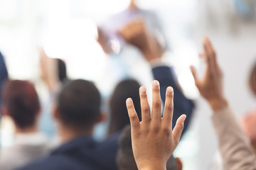 Hands raised in a business seminar